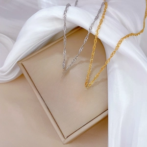 Gold and silver minimalist titanium steel cross necklaces on beige jewelry box and silk