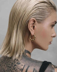 Close-up of model wearing 18K gold two-tone heart drop earrings with polished finish