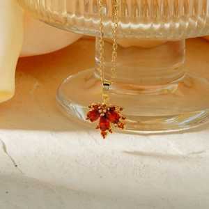 Collana con ciondolo a foglia d'acero dorata e pietre in zircone rosso con catena sottile
