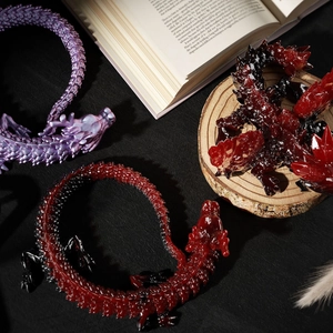Artistic layout of articulated crystal dragons in purple and gradient red resin styles