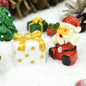 Close-up of Santa Claus and white gift box resin miniatures in a snowy Christmas scene