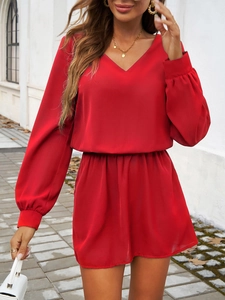 Détail de la robe rouge à col en V avec manches lanternes et taille élastique en extérieur