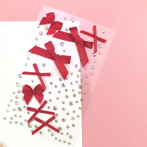 Macro shot of dark red ribbon bows and iridescent rhinestones for DIY face or nail art