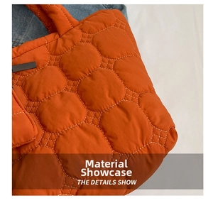 Macro view of orange quilted fabric with hexagonal stitching and light contrast thread detail