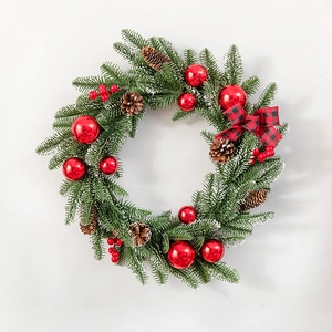 Frosted Christmas wreath with pine needles, red ornaments, pine cones, and a plaid bow