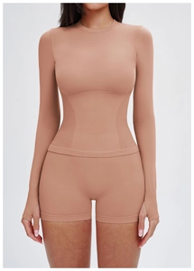 Details des nudefarbenen Yoga-Tops mit Daumenlöchern und geripptem Taillenkompression