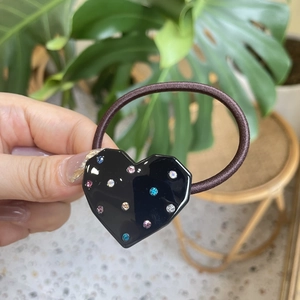 Detail of high-elasticity dark brown hair tie with heart-shaped crystal hair accessory