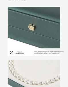 Close-up of green leather jewelry box with gold crown and pearl necklace details