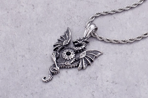 Macro detail of steampunk dragon pendant with black gemstone and twisted chain