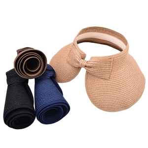 Detail of roll-up straw sun visors for women showing portable foldable design and bow