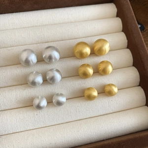 Matte brushed metal ball studs set in gold and silver showing three different sizes