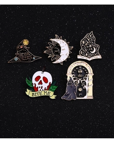 Detailed view of enamel wizard hat, skull apple, and sorcerer pins on black glitter surface