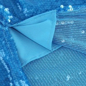 Macro shot of blue sequins and sheer mesh fabric on a stylish bodycon slit dress