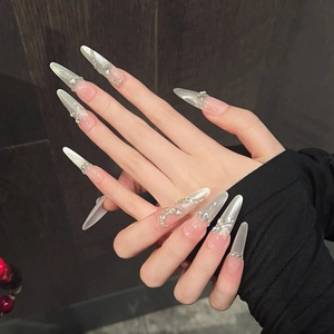Vue détaillée de faux ongles longs amandes avec motifs papillon argenté et lune
