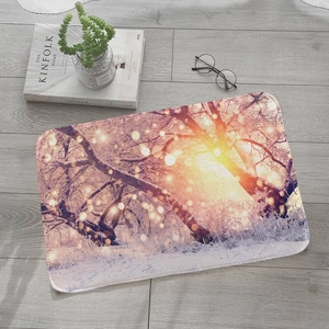 Absorbent flannel floor mat with winter forest sunset design on light wooden floor
