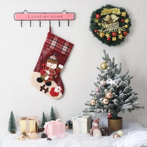 Detail of a red plaid Christmas stocking with a 3D snowman hanging on a festive wall