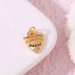 Golden triangle Evil Eye pendant with clear zircon stones on a soft textured background