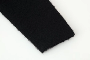 Detailed close-up showing the knit texture and thick ribbed cuff of the black V-neck sweater