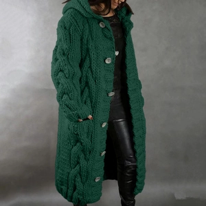 Detailed close-up of chunky cable knit texture on a long dark green hooded cardigan
