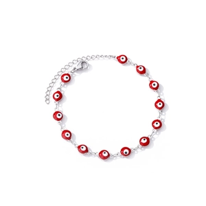 Detailed macro view of red evil eye charm bracelet with silver adjustable lobster clasp