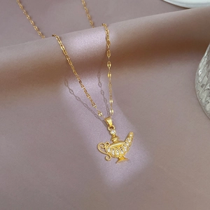 Elegant gold necklace with a micro-pave zircon magic lamp pendant on pink silk