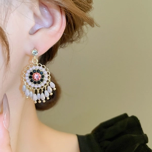 Detailed close-up of retro floral tassel earrings with pink stones and beads in French style