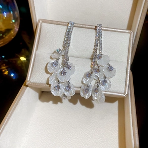 Détail de boucles d'oreilles franges plaquées or 18k avec pétales en zircon élégants