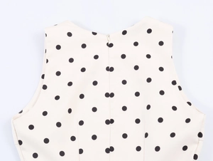 Detailed back view of a polka dot sleeveless top featuring a hidden zipper and waist tucks