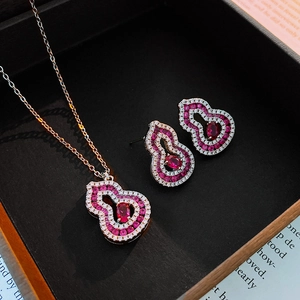 Gros plan de boucles d'oreilles gourde en or rose avec rubis et zircon dans un coffret