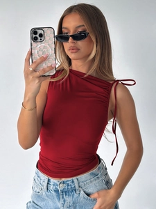 Detail of red drawstring crop top showing side tie design and pleated texture details