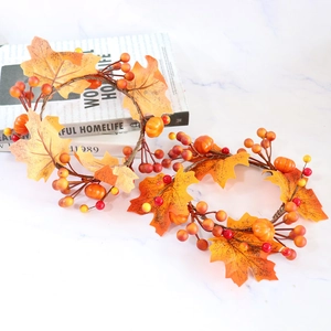 Autumn harvest candle ring with maple leaves, mini pumpkins, and berries on white marble