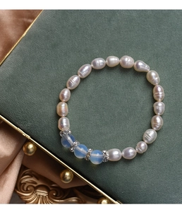 Detailed macro of baroque pearl bracelet with moonlight stones on velvet background