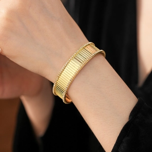 Gros plan du bracelet jonc tricolore à rayures plaqué or avec bordure en diamants brillants