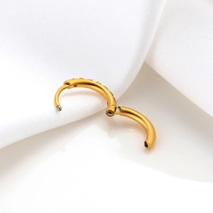 Single gold stainless steel hinged hoop earring with cubic zirconia on white surface