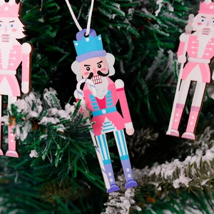 Detailed view of pink and blue wooden nutcracker ornaments hanging on a Christmas tree