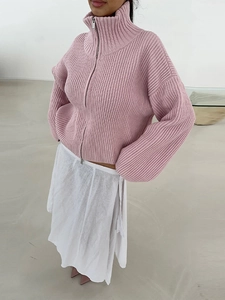Dettaglio del cardigan rosa in maglia grossa con doppia cerniera e collo alto