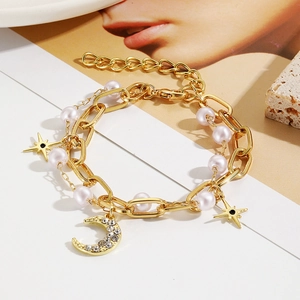 Detail of bohemian gold-layered bracelet with baroque pearls and moon star charms