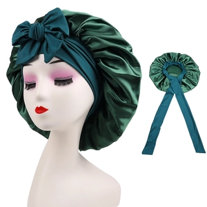 Detail of dark green satin sleep bonnet with elastic wide band and large bow decoration