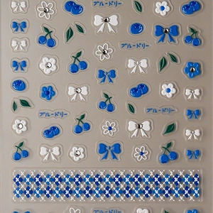 3D embossed nail stickers featuring cobalt blue bows and floral motifs on a grey card