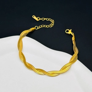 Detailed view of intertwined golden snake bone chain bracelet with lobster clasp