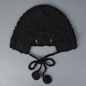 Détail du bonnet au crochet noir fait main avec motifs ondulés et cache-oreilles stylés