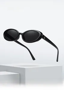 Close-up of retro oval sunglasses with thick black frames and silver rivet detail