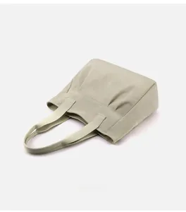 Detail of minimalist beige canvas tote bag showing textured fabric and stitching