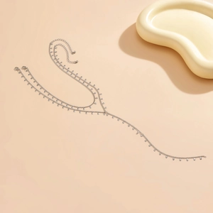 Detail of silver multi-layer body chain with tiny water drop pendants and lobster clasp