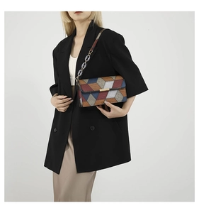 Detailed view of women's geometric patchwork shoulder bag with chain strap on a model