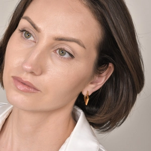 Close-up of minimalist gold geometric V-shaped earrings on model for an elegant fit