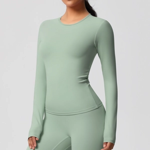 Détail du haut de yoga manches longues vert sauge et du legging de fitness extensible