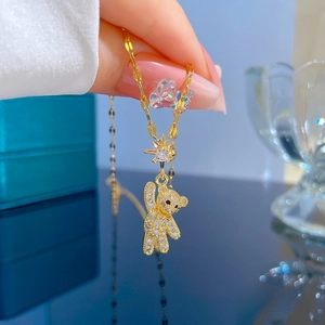 Macro shot of gold teddy bear pendant with sparkling crystals and star detail