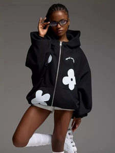 Close-up of oversized black hoodie with floral print and april wings lettering detail