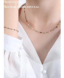 Detail of gold titanium steel necklace and bracelet set with colorful enamel beads